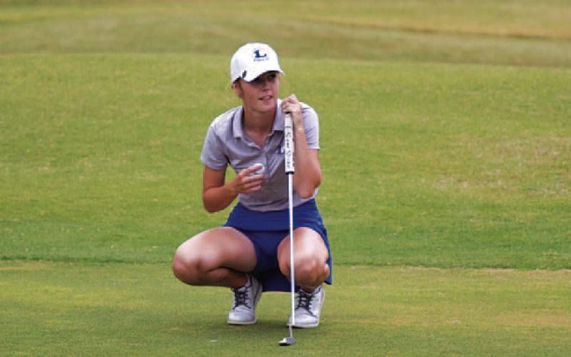 Junior Amber Beuermann prepares to read a putt. The Lady Badgers earned a second-place district finish. HUNTER KING | DISPATCH RECORD