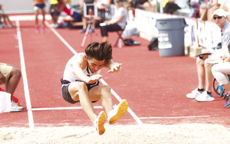HUNTER KING | DISPATCH RECORD White prepares to stick the landing of his second jump at Mike A. Myers Track and Soccer Stadium.