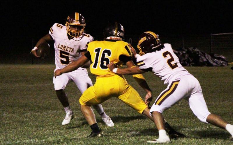 Elijah Gonzales looks for room to run against Jonesboro, while Tim Juarez blocks a defender during the game last Friday. JESSICA MALDONADO | DISPATCH RECORD