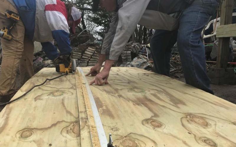 Lampasas High School student Saydie Smith, left, cuts plywood using a circular saw as David Jacobs looks on. MONIQUE BRAND | DISPATCH RECORD