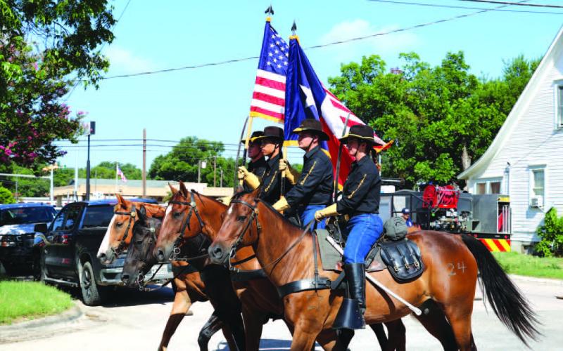 JOYCESARAH MCCABE | DISPATCH RECORD Members of the cavalry unit from Fort Cavazos ride their horses, carrying the American and Texas flags during the Spring Ho Parade.
