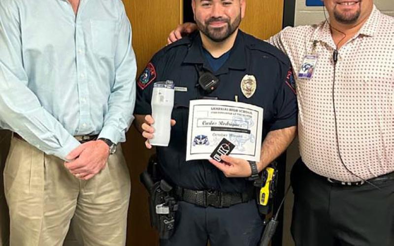 courtesy photo Named the Star Supporter of the Month is Carlos Rodriguez, center, who serves as the high school’s school resource officer. On hand to congratulate him are Clay Phillips, left, of Texas Farm Bureau Insurance and Assistant Principal Ryan Race. “Rodriguez has done a phenomenal job, often going above and beyond his required duties,” said Race.