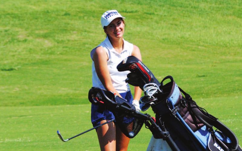 Shaylee Wolfe smiles after a shot during the state golf tournament on Tuesday. HUNTER KING | DISPATCH RECORD