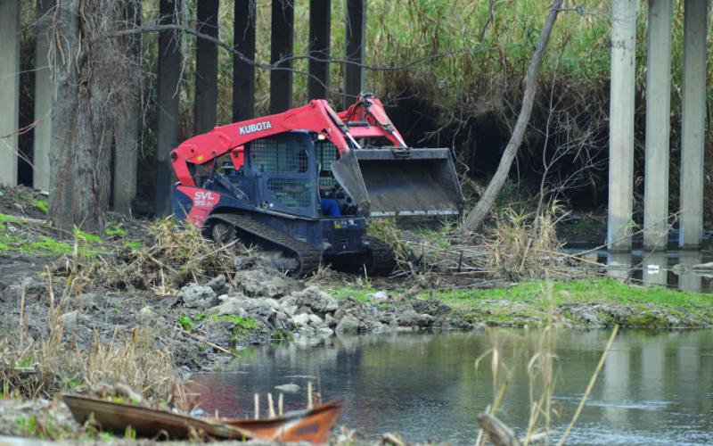 ERICK MITCHELL | DISPATCH RECORD A Lampasas County Precinct 1 vehicle assists in the cleanup along Sulphur Creek near the Fourth Street bridge on Thursday morning. Cleanup efforts along the creek are expected to continue, with a goal of expanding the walking trail in that area.