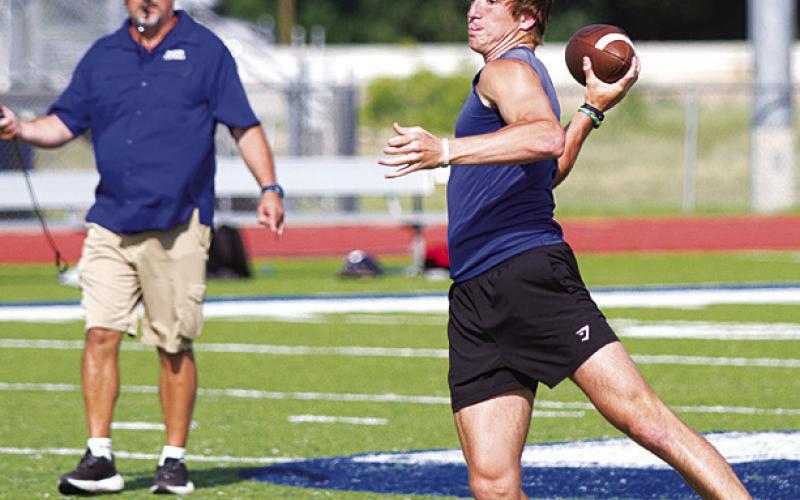 Bryson Roberts looks to thow downfield as he moves to his left during 7-on-7. HUNTER KING | DISPATCH RECORD