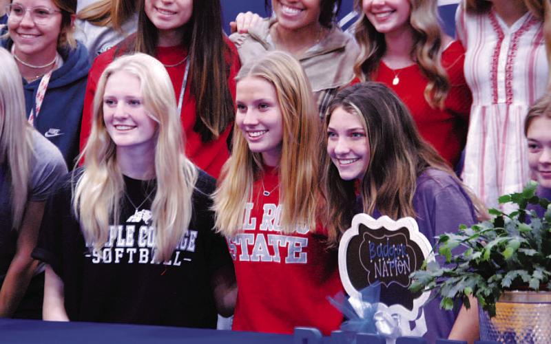 Kali Hunter, left, Bre Quarles and Nyla Long take a photo with their fellow Lady Badgers after signing thier letters of intent last Wednesday. HUNTER KING | DISPATCH RECORD