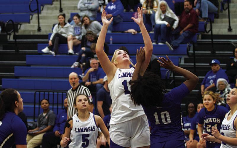 HUNTER KING | DISPATCH RECORD Keaton Owen jumps to grab a rebound over a Lady Bulldog.