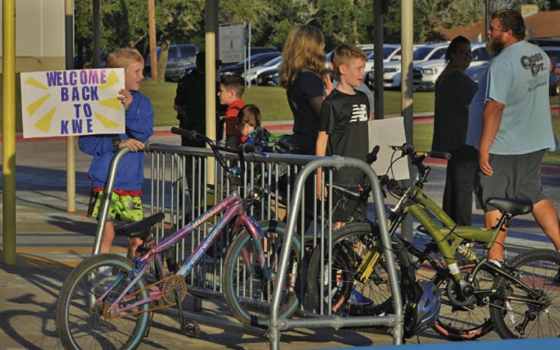 Kline Whitis Elementary School students hold welcome signs for fellow classmates and parents on the first day of the new school year. ERICK MITCHELL | DISPATCH RECORD