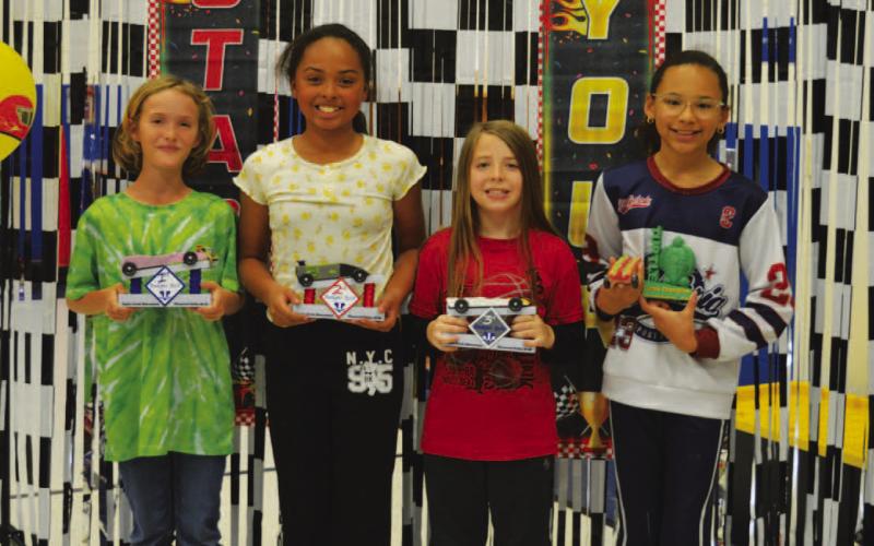 From left, Willow Gardner (first place), Violet Gude (second place) and Ryker Scott (third place) were the top competitors in last week’s derby. At right, Jordyn Burnett garnered the turtle award for having the slowest car in the race. ERICK MITCHELL | DISPATCH RECORD