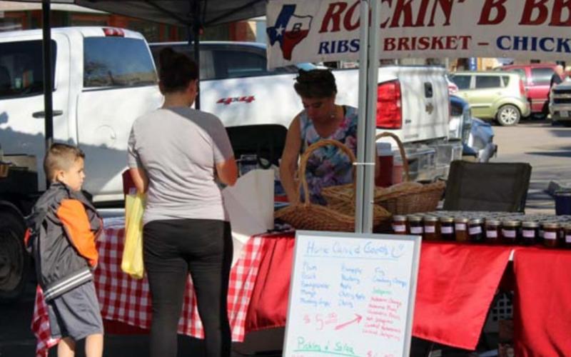 High school counselor Christine Byrd serves up her family’s barbecue at the Lampasas farmers’ market. VERONICA BUTLER | DISPATCH RECORD