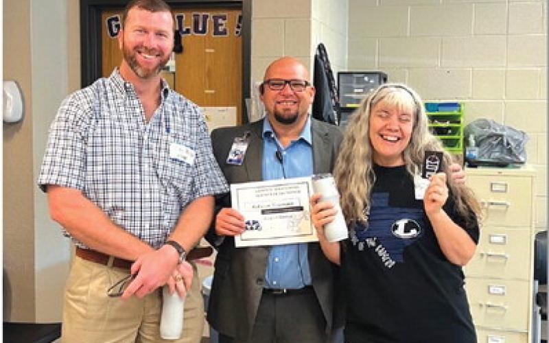 COURTESY PHOTO Clay Phillips of Texas Farm Bureau Insurance, at left, joins Lampasas High School Assistant Principal Ryan Race in congratulating Rebecca Veroneau on her selection as the campus’ Teacher of the Month for August. “She is a problem-solver with a heart of gold, and we are blessed to have her,” Race said of the Life Academics teacher.