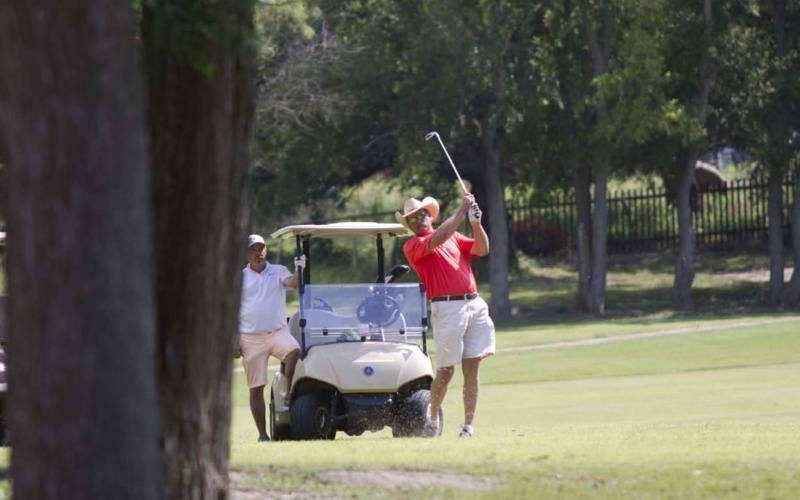 Warren Thornton follows through on a shot on Hole No. 5 during the afternoon tournament benefiting the high school golf program. HUNTER KING | DISPATCH RECORD