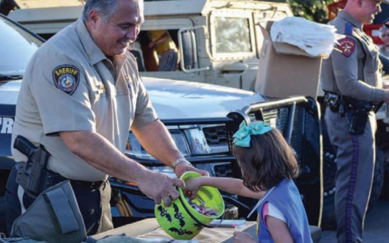 Sheriff Jess Ramos offers candy to then 5-year-old Kinsleigh Delgado during Lampasas’ National Night Out celebration in 2019. National Night Out is intended to connect communities with their law enforcement agencies. FILE PHOTO