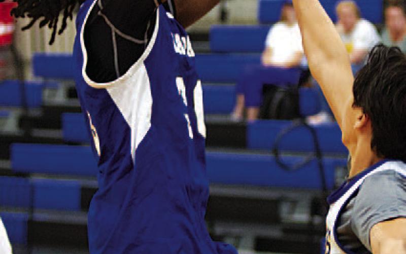 HUNTER KING | DISPATCH RECORD Adonis Fleming shoots over a defender against Lago Vista.