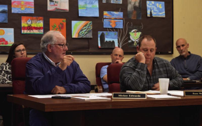 Trustees Mickey Edwards, left, and Sam Walker review construction numbers for bond propositions that are planned to go before voters in May. ERICK MITCHELL | DISPATCH RECORD