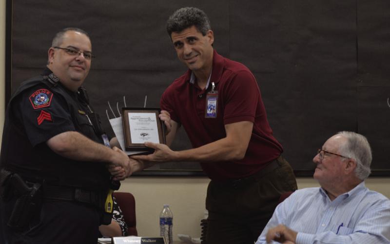 School Resource Officer Steve Sheldon, at left, was recognized at the Lampasas ISD Board of Trustees meeting where Superintendent Dr. Chane Rascoe presents the outgoing sergeant with a plaque honoring his service to the community. Sheldon plans to retire from the Lampasas Police Department at the end of June. Also pictured, at right, is trustee Mickey Edwards. ERICK MITCHELL | DISPATCH RECORD