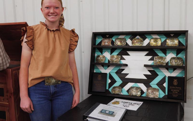 Lometa senior Selie Hodge poses for a photo with her 2026 ag mechanics project, a shelf to hold belt buckles aquired through livestock show competitions over the years. ADAM BARRIOS | DISPATCH RECORD