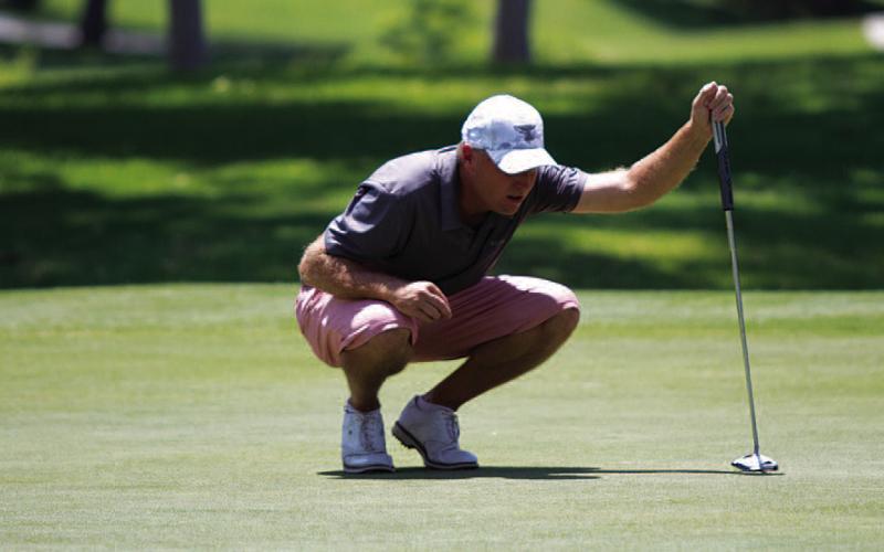 HUNTER KING | DISPATCH RECORD Golf coach Justin Schulze reads a putt during Saturday play at the Memorial Tournament.