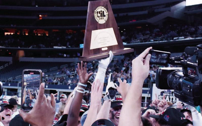 The state championship trophy is lifted high by a victor from 2022. FILE PHOTO