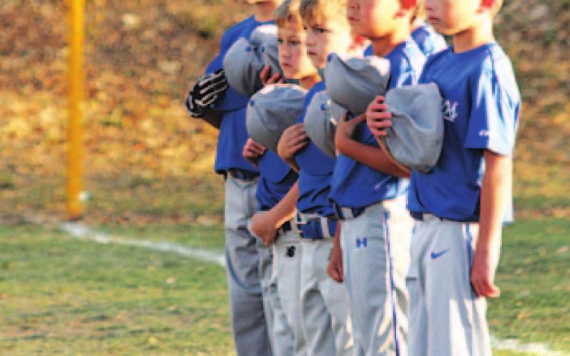 Youth ball players stand for the national anthem on opening day. COURTESY PHOTO