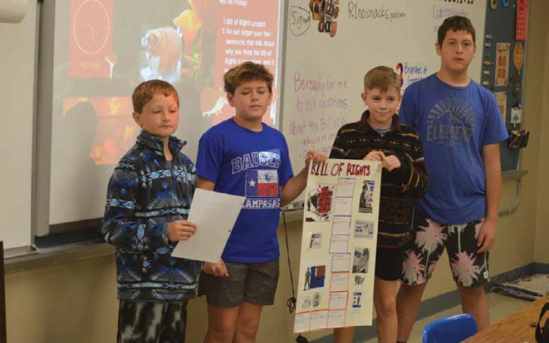 From left are students Kash Kreider, Shade Clouds, Trigg Hill and Bentley Larsen as they present their Bill of Rights poster during class on Wednesday. Erick Mitchell | Dispatch Record