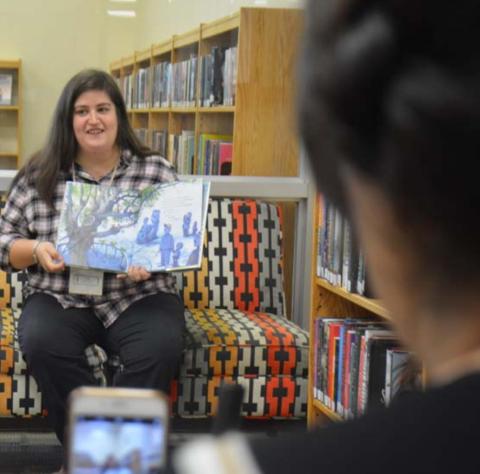 Assistant Librarian Emily Stone reads “This Very Tree” by Sean Rubin, while Library Clerk Sammi McKenzie livestreams on her phone during the weekly storytime Wednesday morning at the Lampasas Public Library. MONIQUE BRAND | DISPATCH RECORD