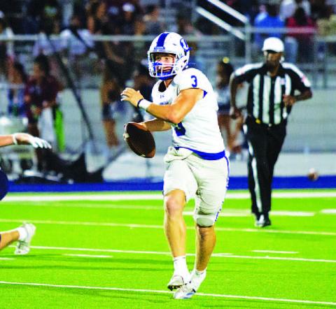 Reed Jerome rolls to his left and looks for a receiver during last Friday’s game. HUNTER KING | DISPATCH RECORD
