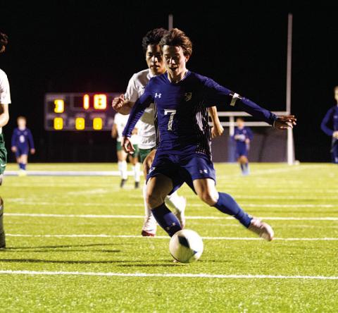 HUNTER KING | DISPATCH RECORD Cooper Pfaltzgraff shoots with his left foot to score against Academy last Friday night.