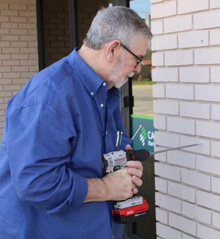 Historical commission member Tom Welch helps mount the plaque at the bank. mason hines | dispatch reacord