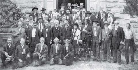 A group of Confederate veterans lined up for the camera on the south side entrance to the Lampasas County Courthouse. Instead of gray uniforms, many of the old men wore gray beards. Date of the photo is unknown. keystone square museum files