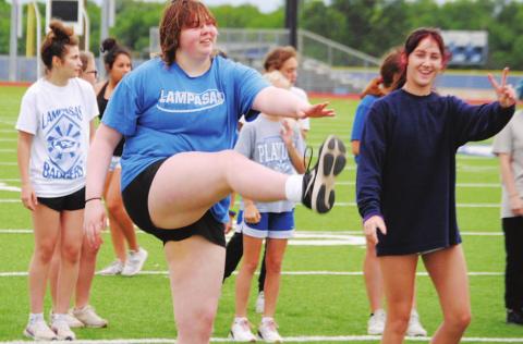 Morgan Lovejoy, left, and Peyton Tatum work through some warmup exercises before starting to run. HUNTER KING | DISPATCH RECORD