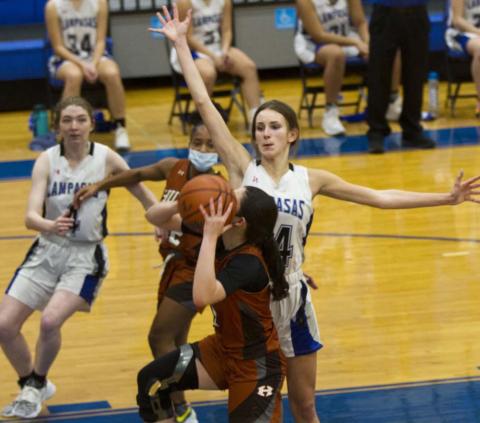 Addison McDonald, right, blocks a Hutto shot while senior teammate Taylor Allen (far left) helps on defense. JEFF LOWE | DISPATCH RECORD