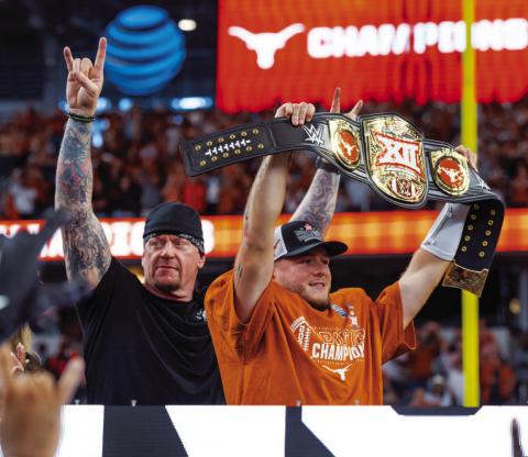 Quinn Ewers, right, poses with the MVP belt from the Big 12 Championship. Standing next to Ewers is professional wrestler, Undertaker. COURTESY PHOTO | TEXAS ATHLETICS