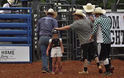Harper Crawford receives a pat on the head for her efforts in Saturday’s mutton bustin’ competition. ERICK MITCHELL | DISPATCH RECORD