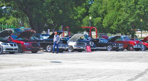 Residents walk along the park road and check out different kinds of vehicles during Saturday’s Sulphur Creek Car Cruise in W.M. Brook Park. hunter king | dispatch record