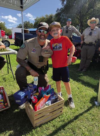 Brian Watson (left) sheds a smile after catching the smallest fish at doLampasas’ Fishes and Loaves Festival on Sunday. Lampasas County Game Warden Ray Milloway joined in to congratulate him.