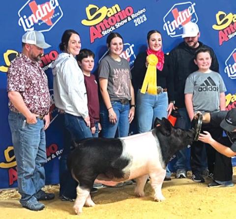 Lampasas FFA member Avery Hopson, center, took fifth place with her heavyweight dark crossbred hog at the San Antonio Livestock Show. court esy photo