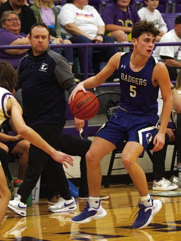 HUNTER KING | DISPATCH RECORD Trent Seneca dribbles down the court as head coach Aaron Nuckles looks on.