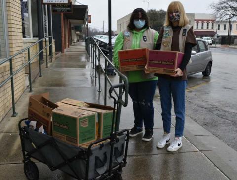 Maggie Ochsner, left, and Charlotte Carmack, members of Lampasas Girl Scout Unit 712, prepare to sell cookies to businesses on the courthouse square on the first day of their selling season. MADELEINE MILLER | DISPATCH RECORD