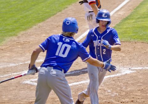 District MVP Ace Whitehead high-fives first-team all-district infielder Eli Stanley after Stanley scored a run in the playoffs. 