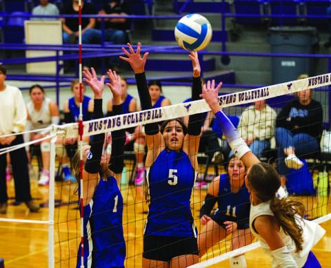 Ysa Swain (5) and Brailey Wilson (1) leap for a block during the Lady Badgers’ match against Marble Falls on Tuesday. HUNTER KING | DISPATCH RECORD