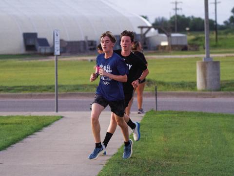 Parker Boykin, front, and Gabriel Allison round the corner during the Monday morning run. HUNTER KING | DISPATCH RECORD