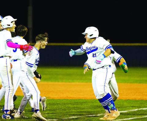 Benny Rodriguez (21) celebrates with his teammates after knocking in the winning run. HUNTER KING | DISPATCH RECORD