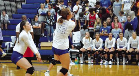 Maggie Fletcher, right, plays a pass as Emily Cain backs her up during the Lady Badgers’ match against Shoemaker.