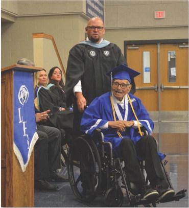 Lampasas High School Assistant Principal Ryan Race assists Guadalupe “Wally” Dimas as he waits to receive his hgh school diploma last week – something Dimas has yearned for most of his adult life. ERICK MITCHELL | DISPATCH RECORD