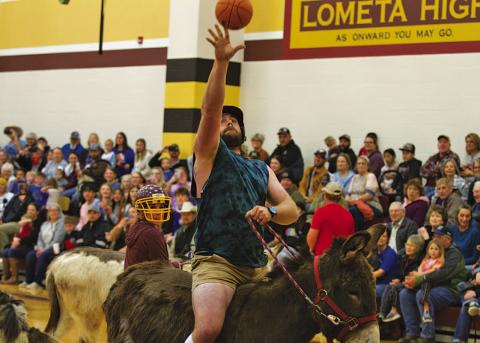 HUNTER KING | LAMPASAS DISPATCH RECORD Sam Pauly tosses the ball toward the hoop during Saturday night’s Donkey Basketball game.