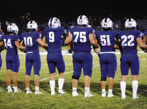 The Badgers stand locked arm in arm during the coin toss before every game. HUNTER KING | DISPATCH RECORD