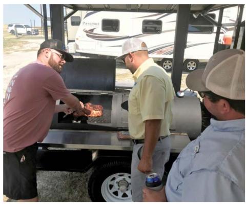 Teammates TJ Wright, at left, Brodi Bocnegra and Wes Canales prepare their meat in last year’s LTX BBQ Fest competition. FILE PHOTO