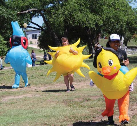 From left to right: Krista Spurgeon, Paula Dowdy and Shirley Tolliver rush to the finish line during one of “Woofstock’s” inflatable races. erick Mitchell | dispatch record