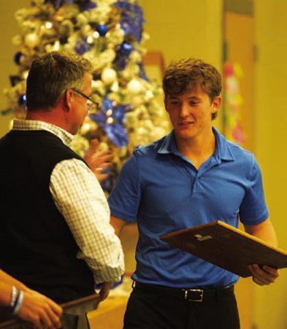 Reed Jerome accepts the Battlin’ Badger award froml head coach Troy Rogers at Monday night’s football banquet. HUNTER KING | DISPATCH RECORD